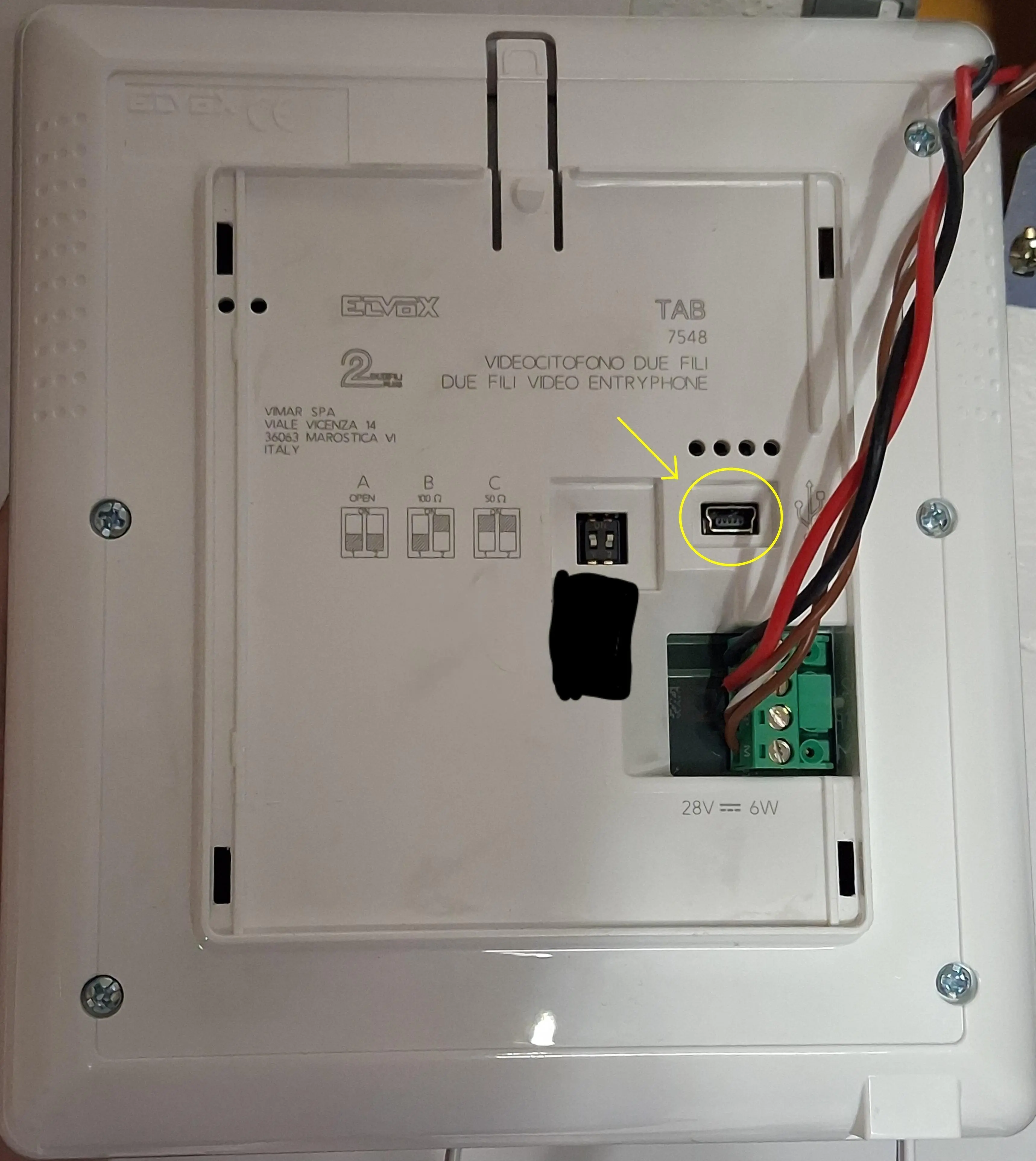 the back of a white slab of a plastic device, showing a mini USB port and a big ass screw terminal with wires coming out of it