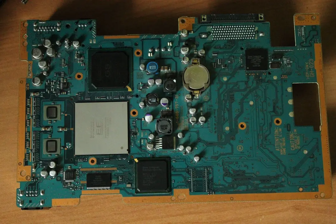 A picture of an emerald-looking PCB. Besides some capacitors and other components, there are two big black BGA chips and one really big silver BGA chip on the left side of the board.