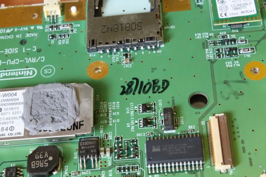 Some chips laying on a circuit board; in the middle, there is something scribbled with a sharpie.